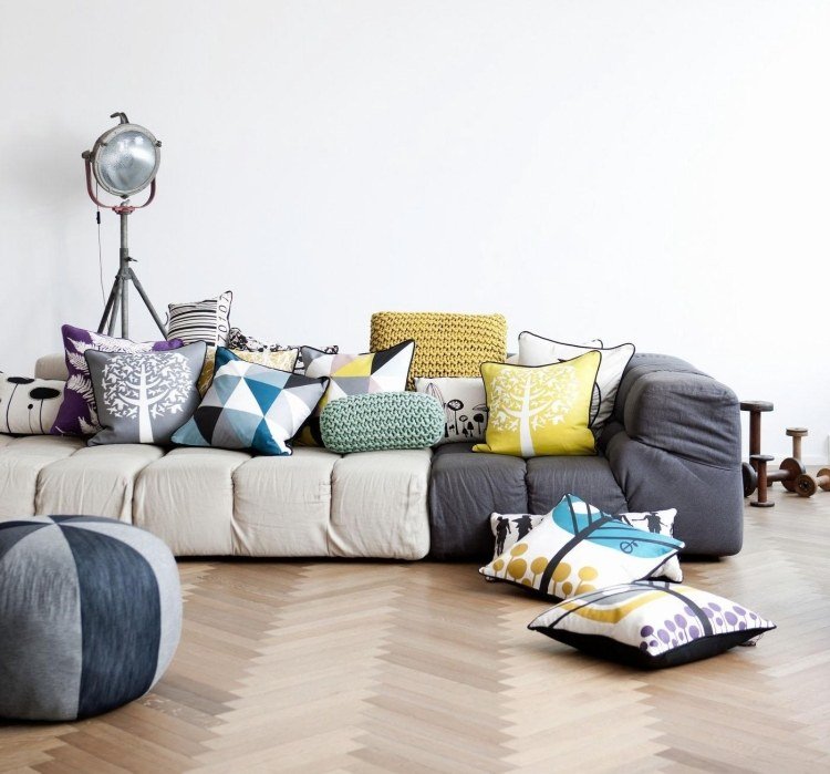 möbleringsidéer-vardagsrum-mysigt-modernt-parkettgolv-modulärt-soffa-grå-kuddar-färgade strålkastare