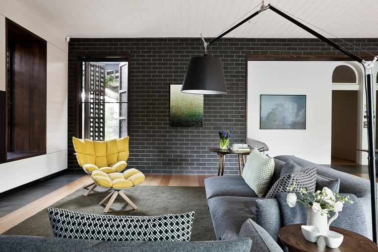 möblering idéer-vardagsrum-mysig-modern-design-grå-hörn soffa-stoppad fåtölj-gul-tegel vägg-tapet