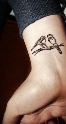 Χαριτωμένα πουλιά στο τατουάζ κλάδου για τον καρπό