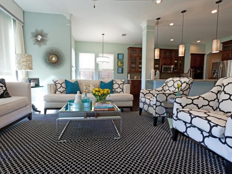 möbleringsidéer-vardagsrum-svart-vit-matta-klädsel-fåtölj-soffbord-dekoration-turkos-hängande lampa