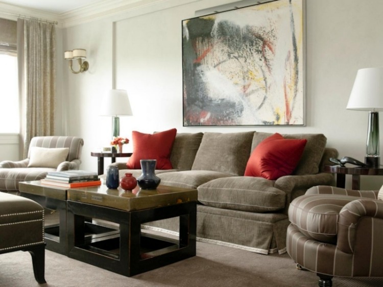 möbleringsidéer-vardagsrum-grå-mörk-stoppade möbler-kuddar-röda-tavlor-abstrakt-bordslampor-deco-soffbord