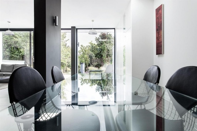 Matsal-möbler-glas-bord-reflektioner-stolar-svart-läder-täckt