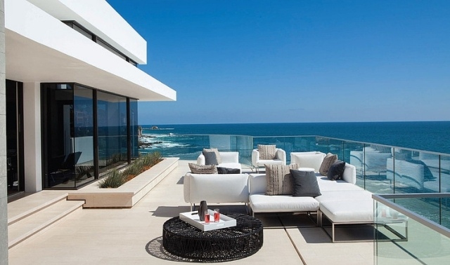 terrass lyxvilla havsutsikt glasräcke vita utemöbler