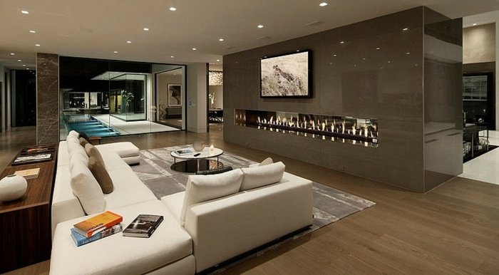 Lyxigt vardagsrum-öppen spis-trägolv-rumsdelare-matsal-vit rektangulär soffa
