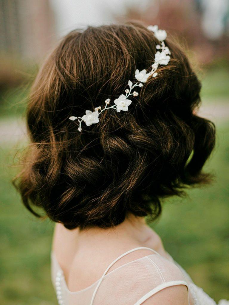 Feminin brudfrisyr med kort hår och hårtillbehör med blommor