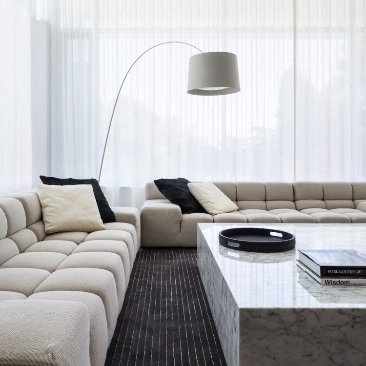 vardagsrum-inredning-grå-marmor-soffbord-golvlampa-mattor-svarta gardiner