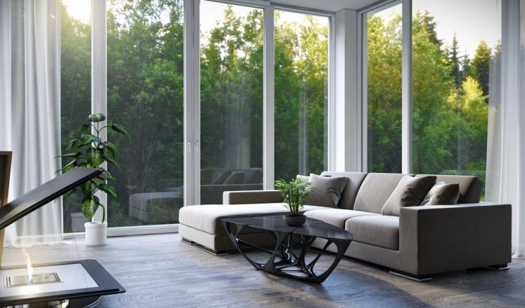 vardagsrum-möblering-hörn-soffa-grå-soffbord-moderna-glas-fronter-gardiner-öppen spis