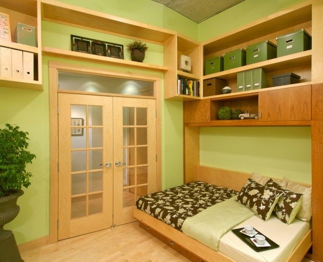 litet sovrum utrymme utvidgning trä hyllor säng grön