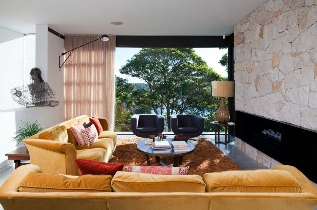 vardagsrum-möbler-stort-fönster-front-sten-öppen spis-beklädnad-senap-gul-soffor