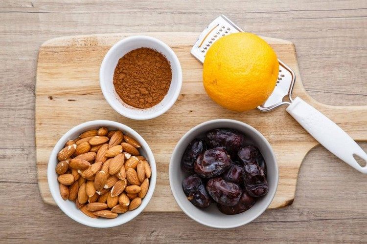 Ingredienser för energibett med dadlar, kakao, mandel och apelsin