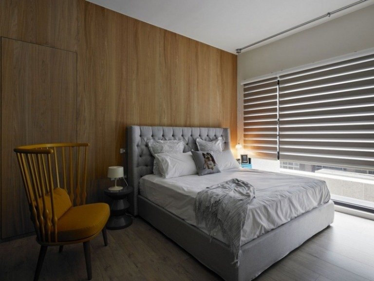 modernt-sovrum-trä-vägg-panel-grå-stoppade säng-quiltade sänggavel