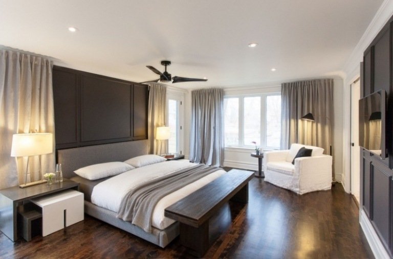 modernt-sovrum-trä-golv-grå-stoppad säng-gardin-belysning