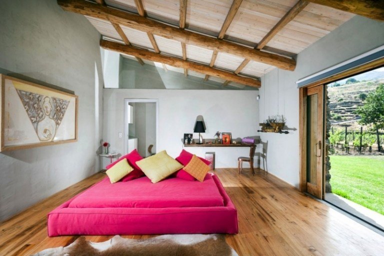sovrum-loft-trä-golv-synliga-takbjälkar-rosa-säng