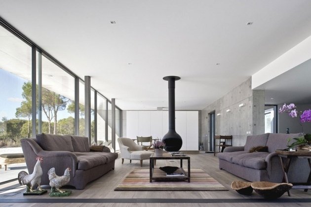 modern-bostad-glas-front-interiör-design-hängande-eldstad-väggar-grå-betong