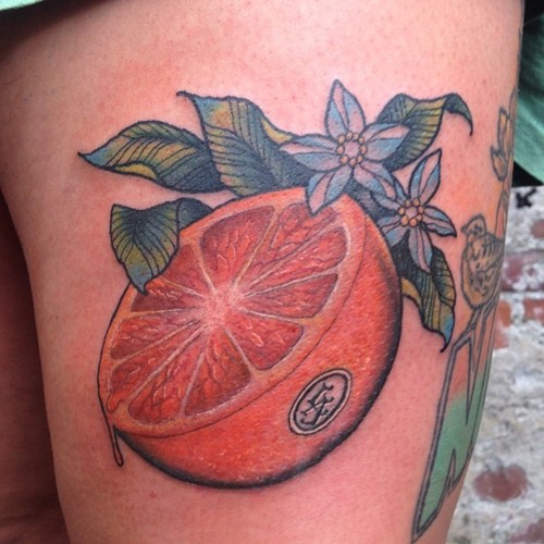 Μισό πορτοκαλί με σχέδιο τατουάζ με πράσινα φύλλα