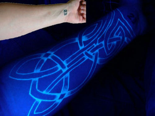 Fluoresoiva musteen tatuointi käsivarteen