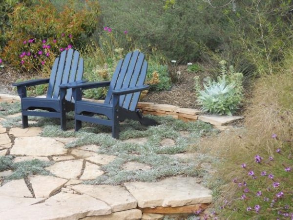 Trädgårdsdesign adirondack stolar stenblommor lila naturmiljö