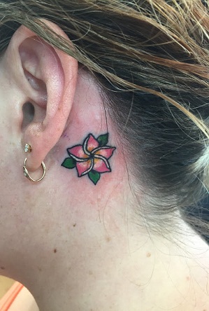 Söpö Plumeria -tatuointi korvan takana