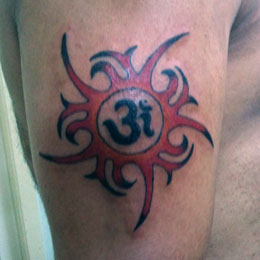 Tribal Sun Tattoo keskellä Om -symboli