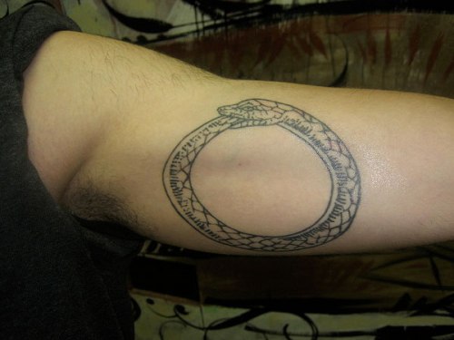Käärme syö häntähäntä tatuointiaan