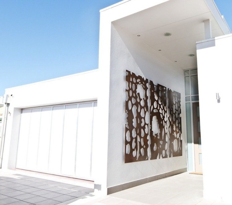 Corten stål dekoration utanför vägghängande hus vit gipsfasad