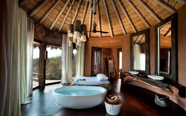 modernt badrum tropisk atmosfär oval badkar massivt trä handfat
