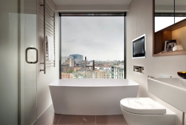 litet badrum city lägenhet fönster badkar inbyggd tv
