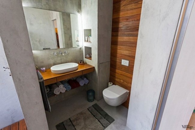 litet badrum betongvägg trä fåfänga hylldukar