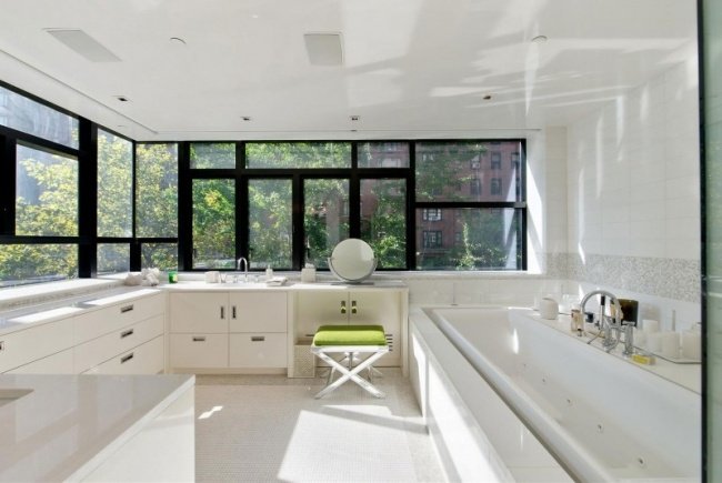 rymligt badrum vita badrumsmöbler badkar fönster