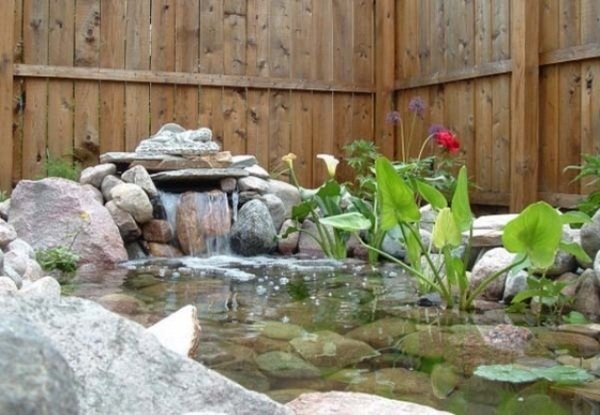 Vattensystem för att må bra med en stendamm i trädgården