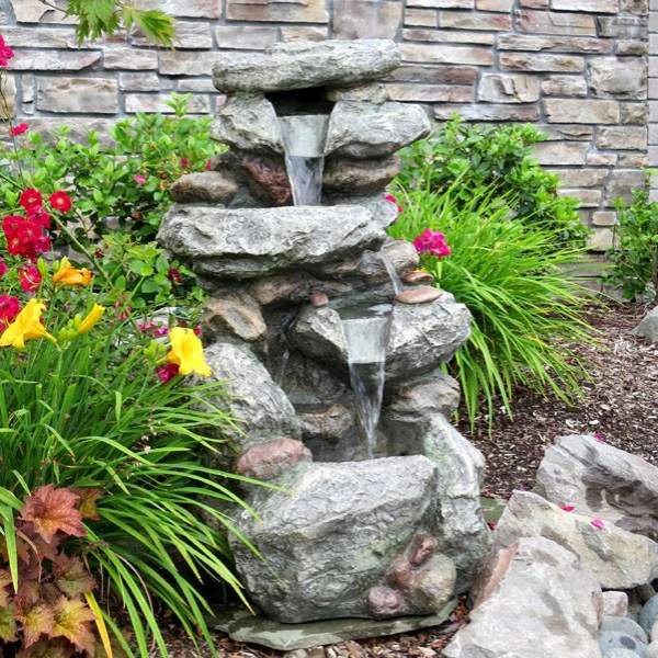Bygg en vattenfontän på bakgården av natursten och övervuxen med växter