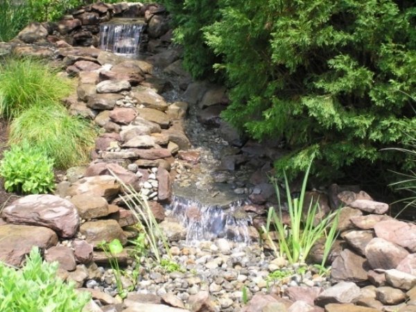 Skapa en trädgårdsdamm med stenar. Designa dina egna vattendrag
