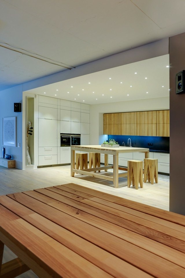 Kök-i-loft-lägenhet-med-massivt trä-bord-och-belysning-i-taket