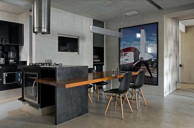 Kök-ö-gjord i granit-med-betong-väggar-svarta stolar