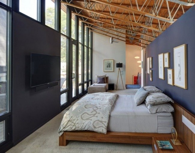 smalt sovrum sluttande tak tv vägg trä säng blå accent vägg