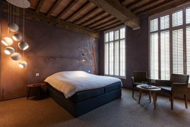 sovrum designer möbler idéer matta golv trä tak hängande lampor lila vägg