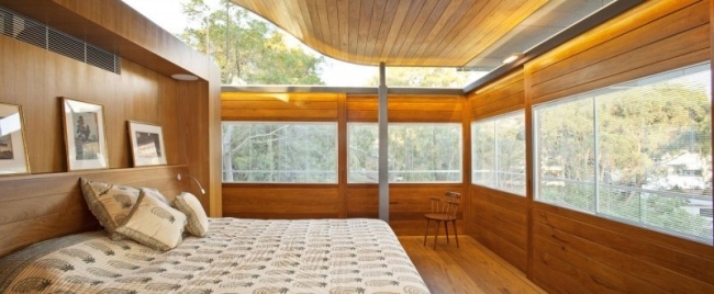 modernt sovrum designerhus skog glastak träbeklädnad infälld belysning
