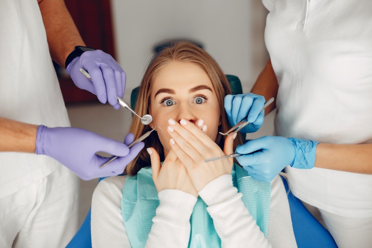 sjuksköterska och tandläkare behandlar ängslig patient