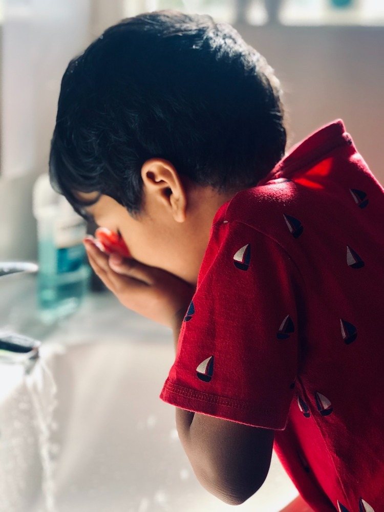 barnet håller munhygien och använder antibakteriella munsköljningar