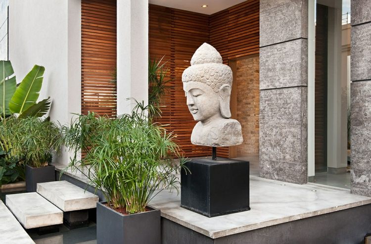asiatisk-trädgård-dekoration-buddha-staty-grå-sten-palm-bananträd