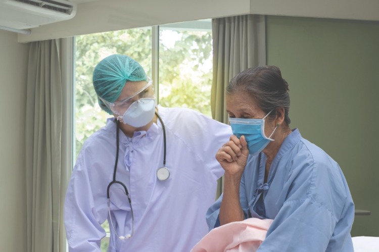 Kvinnlig läkare undersöker patienten för coronasymtom orsakade av hosta