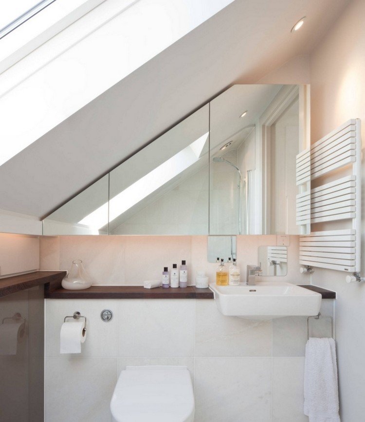 litet badrum-sluttande tak-spegel-skåp-diskbänk-hyllor-led-remsa