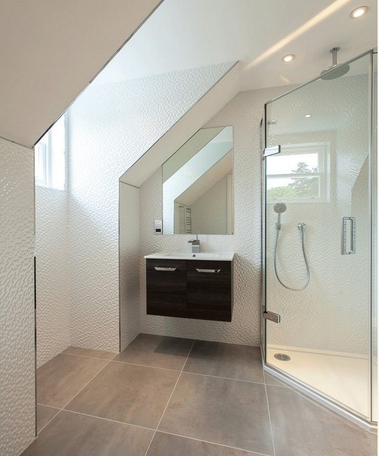 litet-badrum-sluttande tak-hörn-dusch-skåp-vita-väggplattor-relief-vägg-badrumsskåp