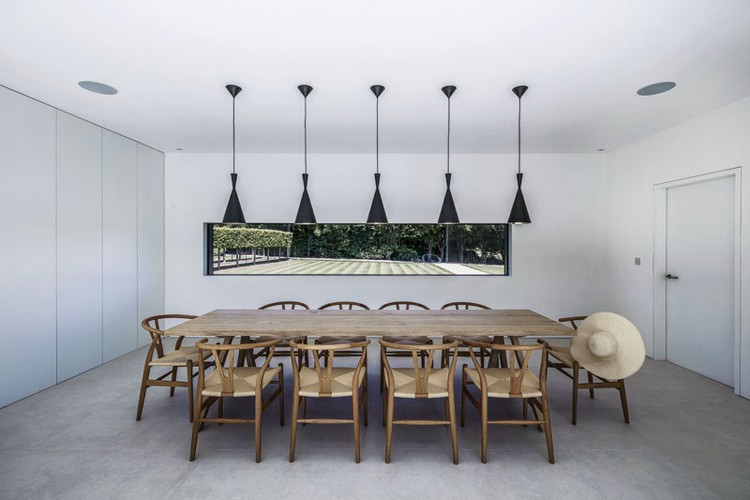 matsal-trä-bord-svart-hängande-lampor-fönster-utsikt-trädgård