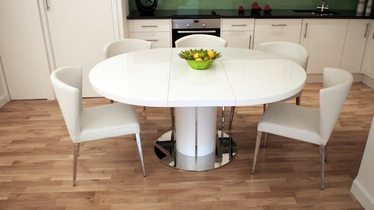 Utdragbart matbord i vita, ovala högglansiga stolar, modern parkett