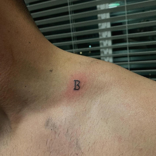 B Letter Tattoo Near The Neck