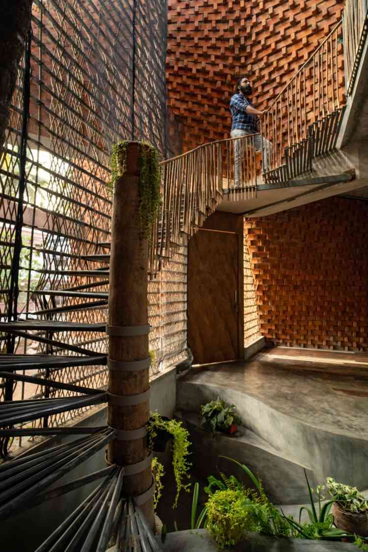 ovanlig trappa gjord av återanvända material som bambu och metallgaller i ett modernt hus