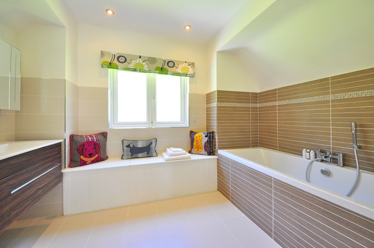 Badrumsdesign brun beige vit badkar duschhuvud mosaik kant