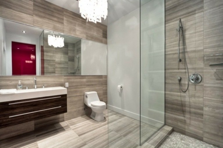badrum med dusch grå kakel badrumsskåp flytande effekt spegel