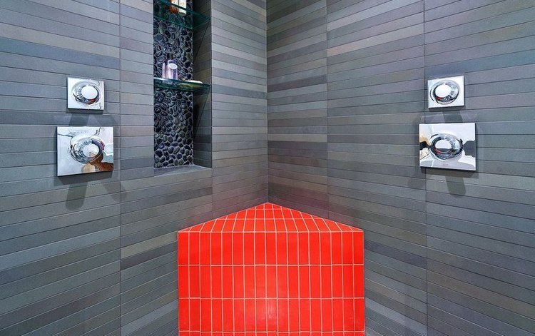 kontrasterande röda sittplatser i badrummet med sten- och remnisch och modern design